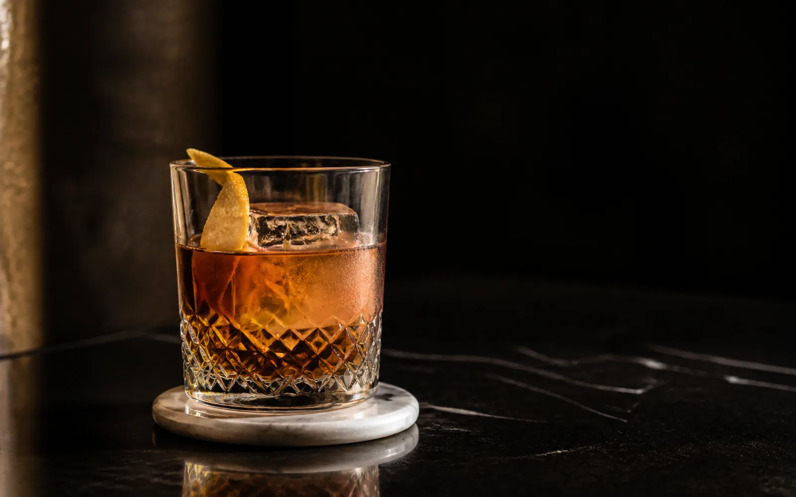 Concept preview of a precisely made classic cocktail with clear ice and citrus
